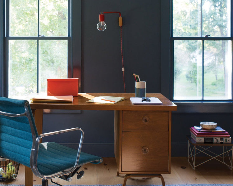 wooden desk and blue office chair in front of two windows